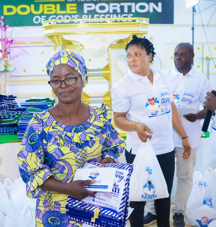 A woman smiles as the Foundation team hands her a gift at the widows&rsquo; outreach in Akute.