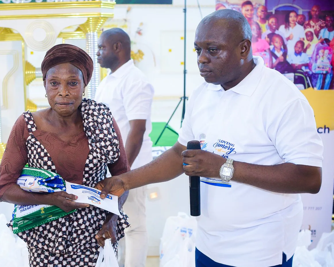 A member of the Foundation team hands support to a woman at an outreach in Akute.
