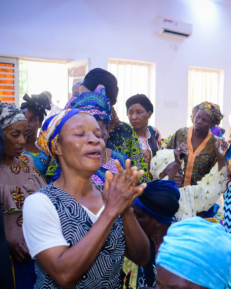 A woman lifts her hands in praise at the Foundation&rsquo;s widows&rsquo; outreach in Akute.