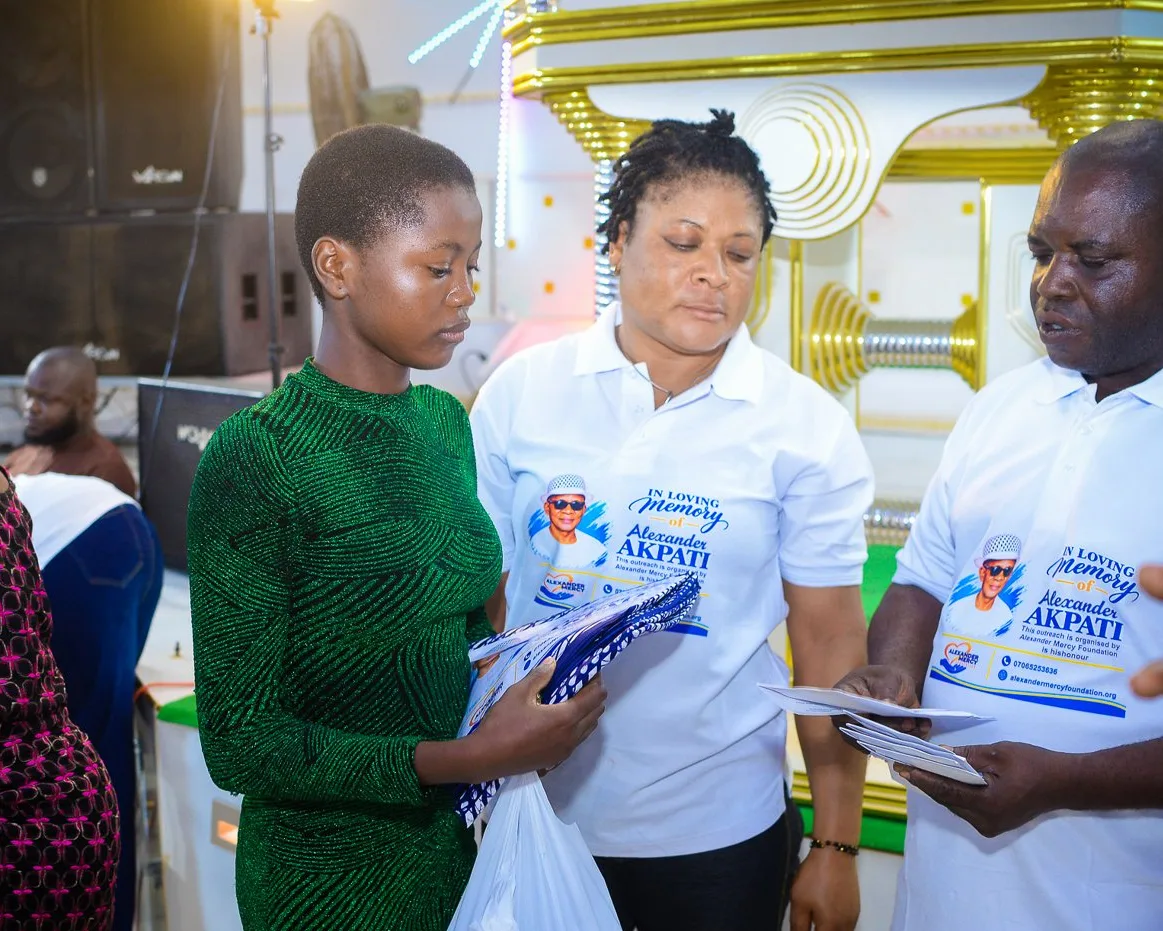 Foundation volunteers hand support to a young woman at the outreach in Akute.