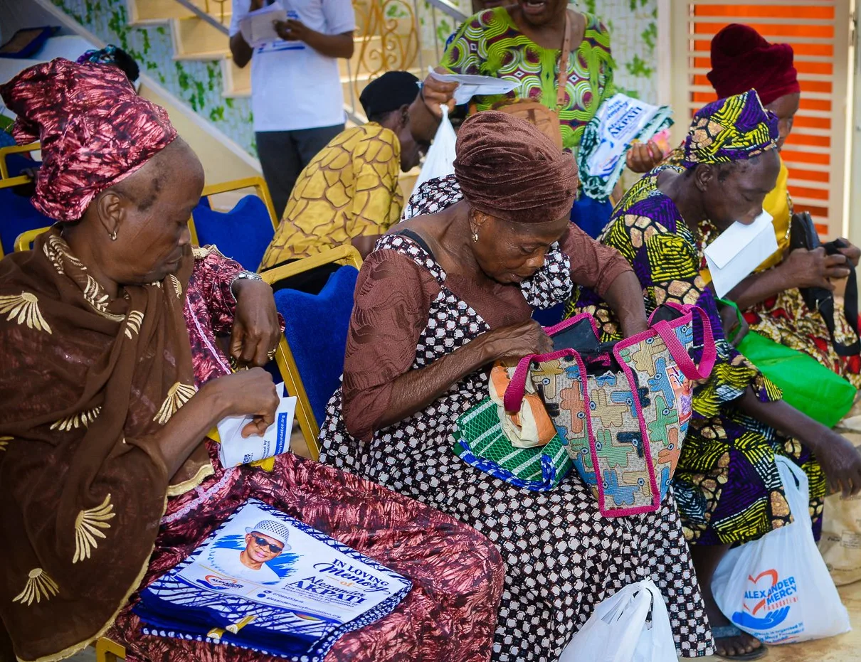 Older women look through the gifts they received at the Foundation’s widows’ outreach in Akute.