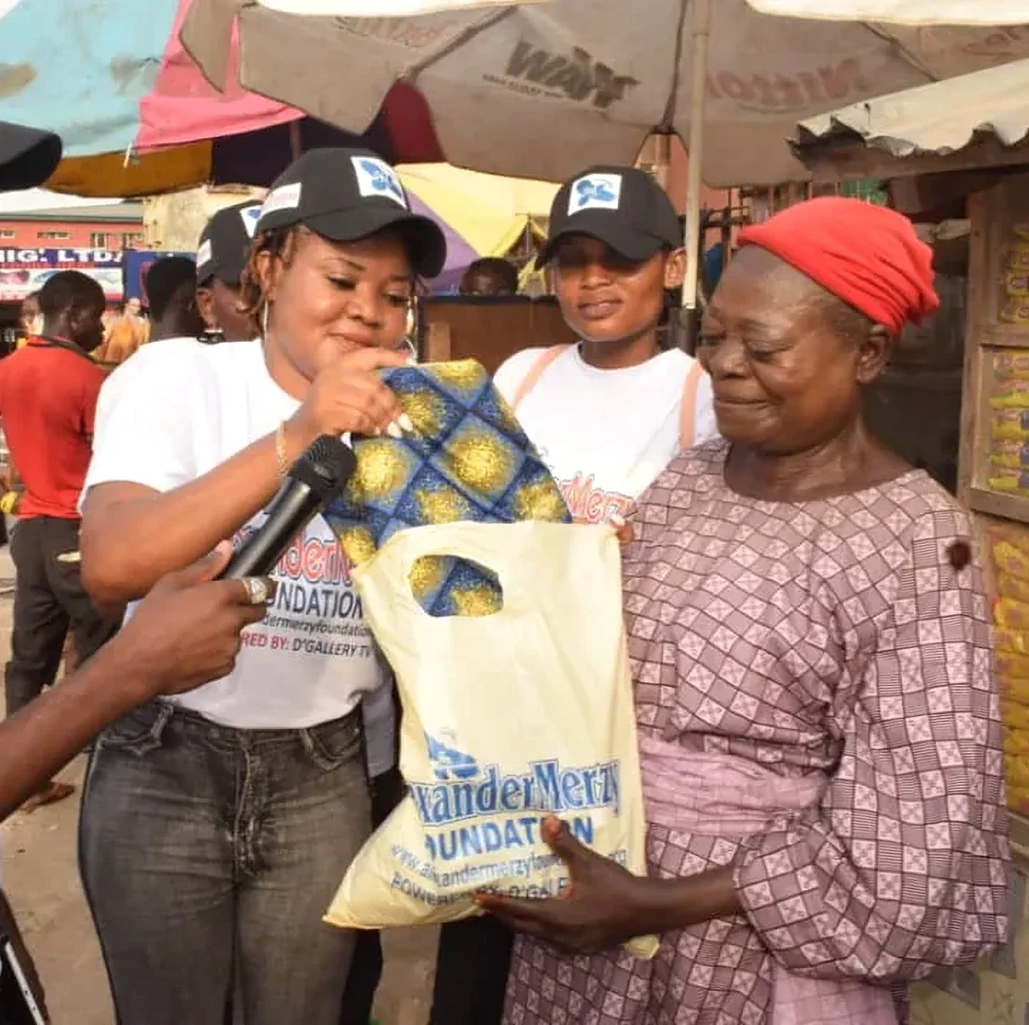 Foundation volunteers hand a gift bag to a market trader at the Mother’s Day outreach.